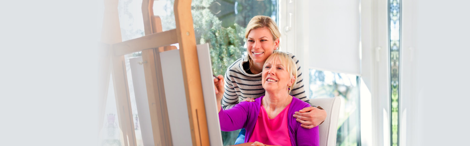 caregiver and elderly woman painting